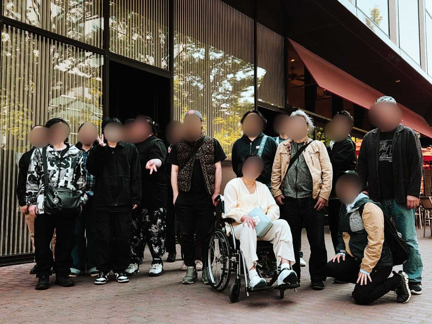 鶴雅リゾートのエントランス前で、MAUROAの利用者さん・職員が並んで撮影した集合写真（モザイク済み）