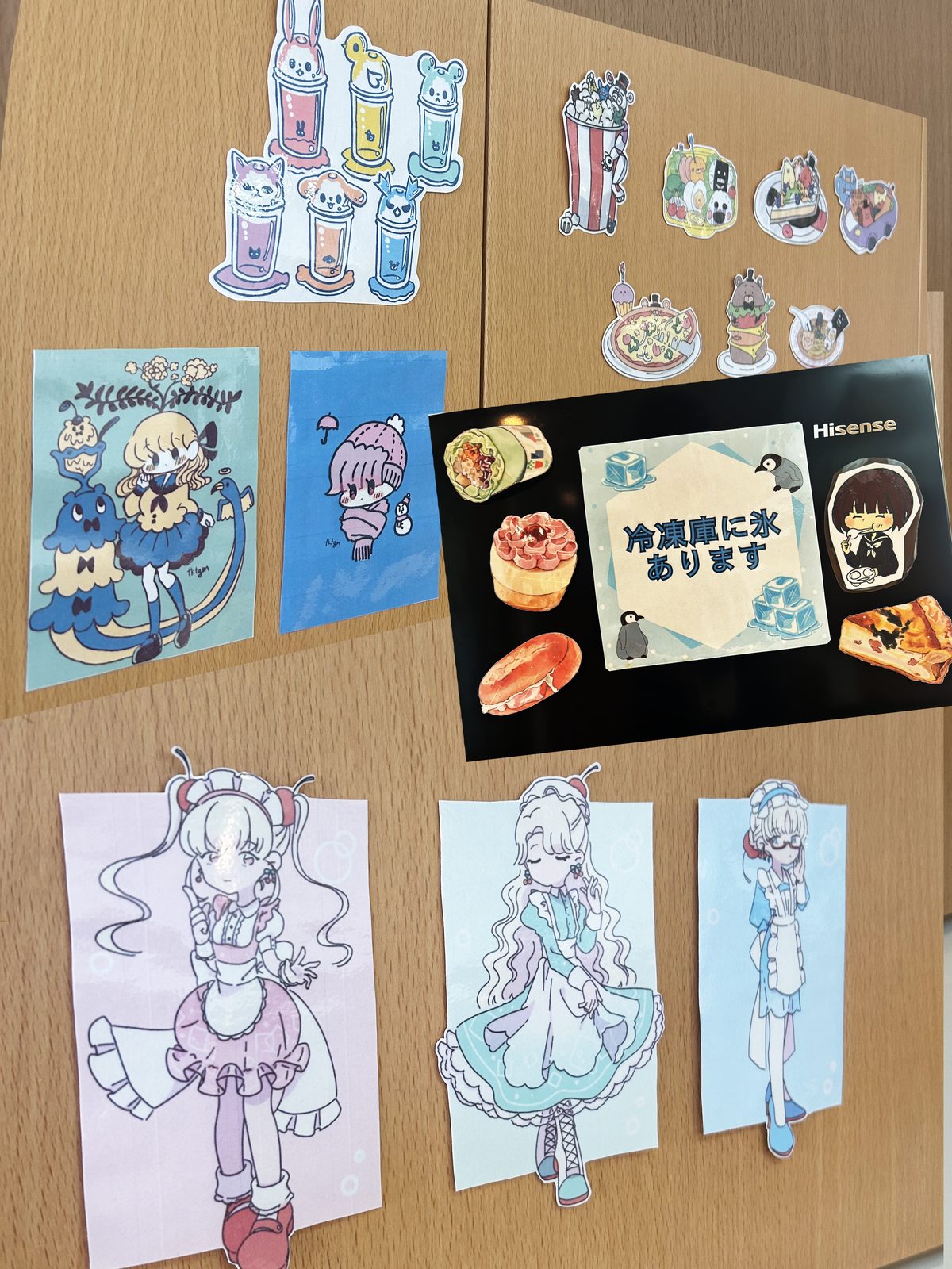 MAUROAの事業所の壁に飾られた、イラストや食べ物のステッカー、メイド服の女の子のイラスト